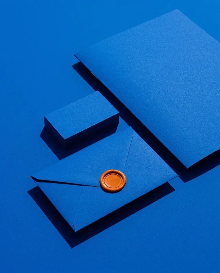 Sobre, tarjetas y carpeta azules cerrados con un lacre naranja